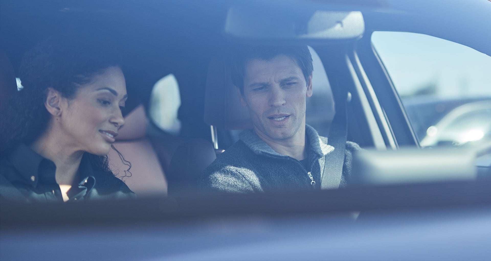 Man and woman looking over a new car dash.