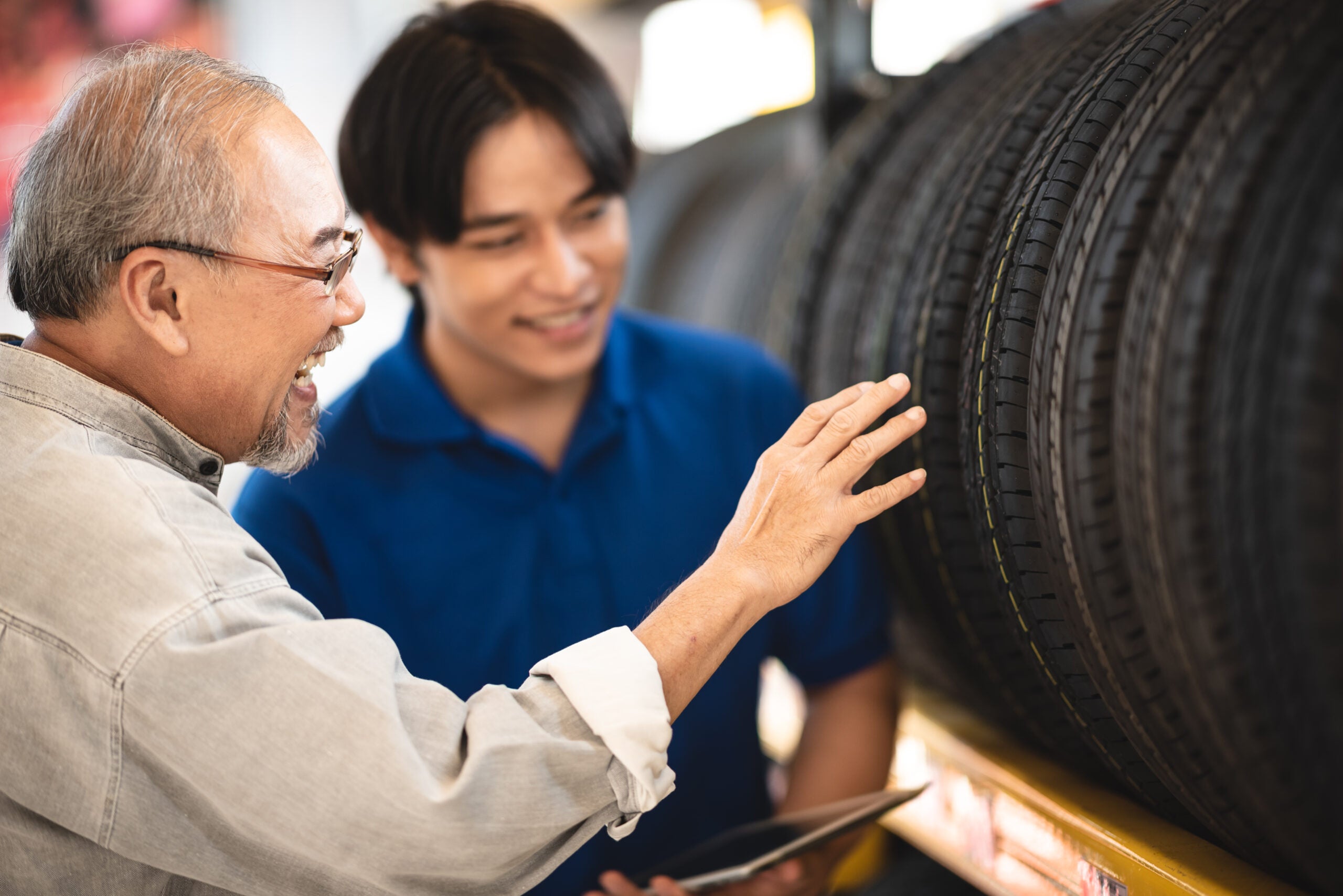 Young man garage owner and salesman go over different tire options.